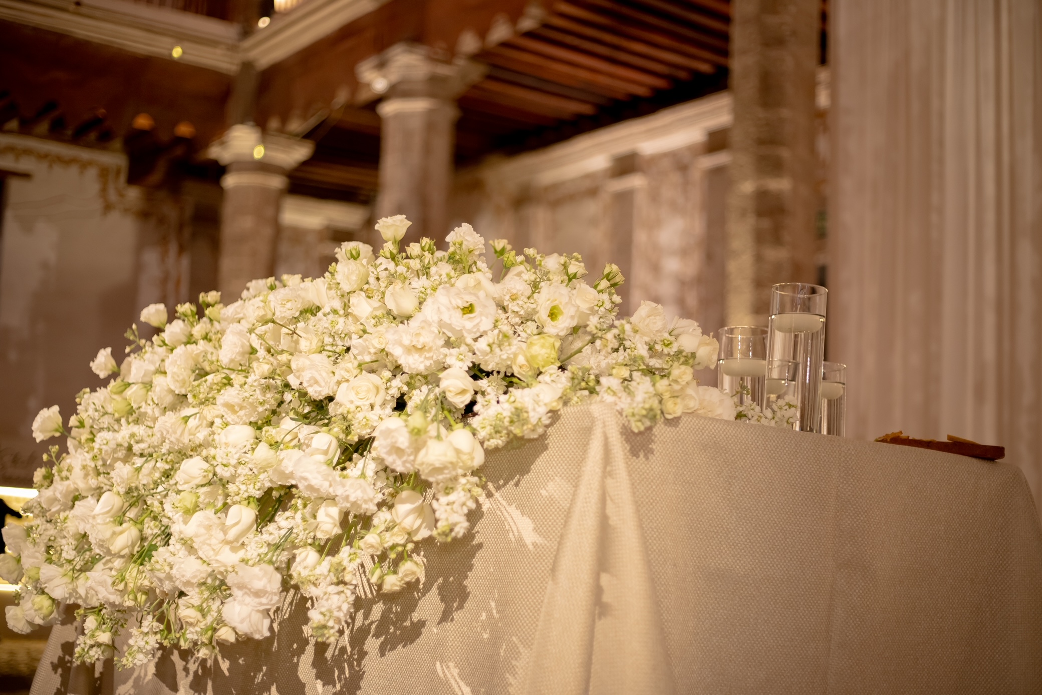 Desk with leather desk pad, walnut desk organizer, wireless keyboard and mouse, and porcelain mug.