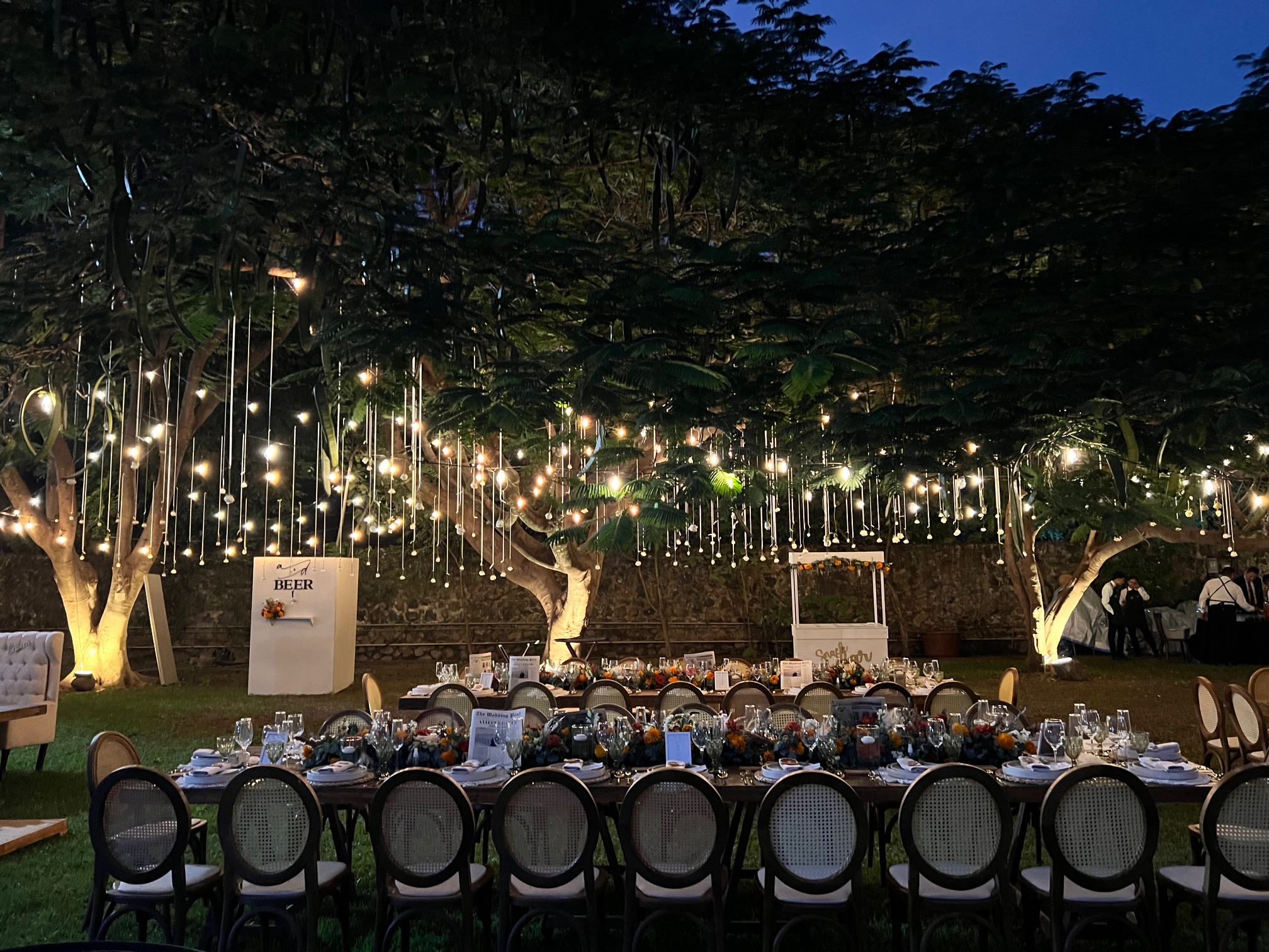 Desk with leather desk pad, walnut desk organizer, wireless keyboard and mouse, and porcelain mug.