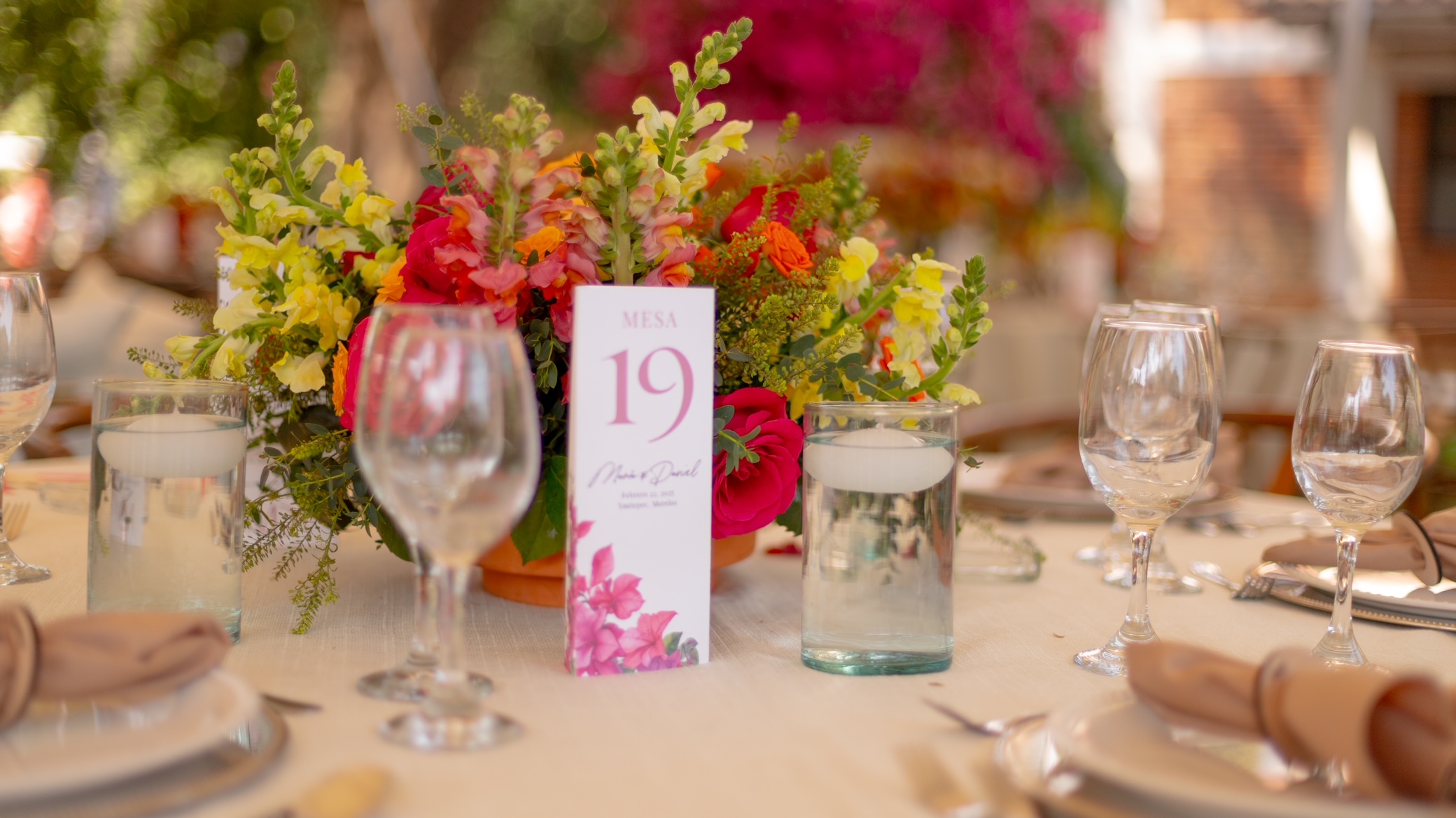 Desk with leather desk pad, walnut desk organizer, wireless keyboard and mouse, and porcelain mug.