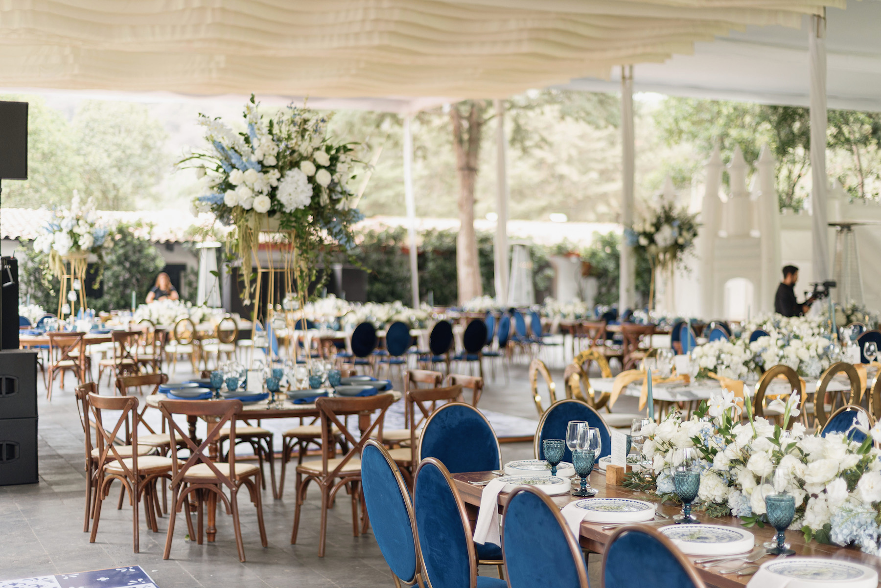 Desk with leather desk pad, walnut desk organizer, wireless keyboard and mouse, and porcelain mug.
